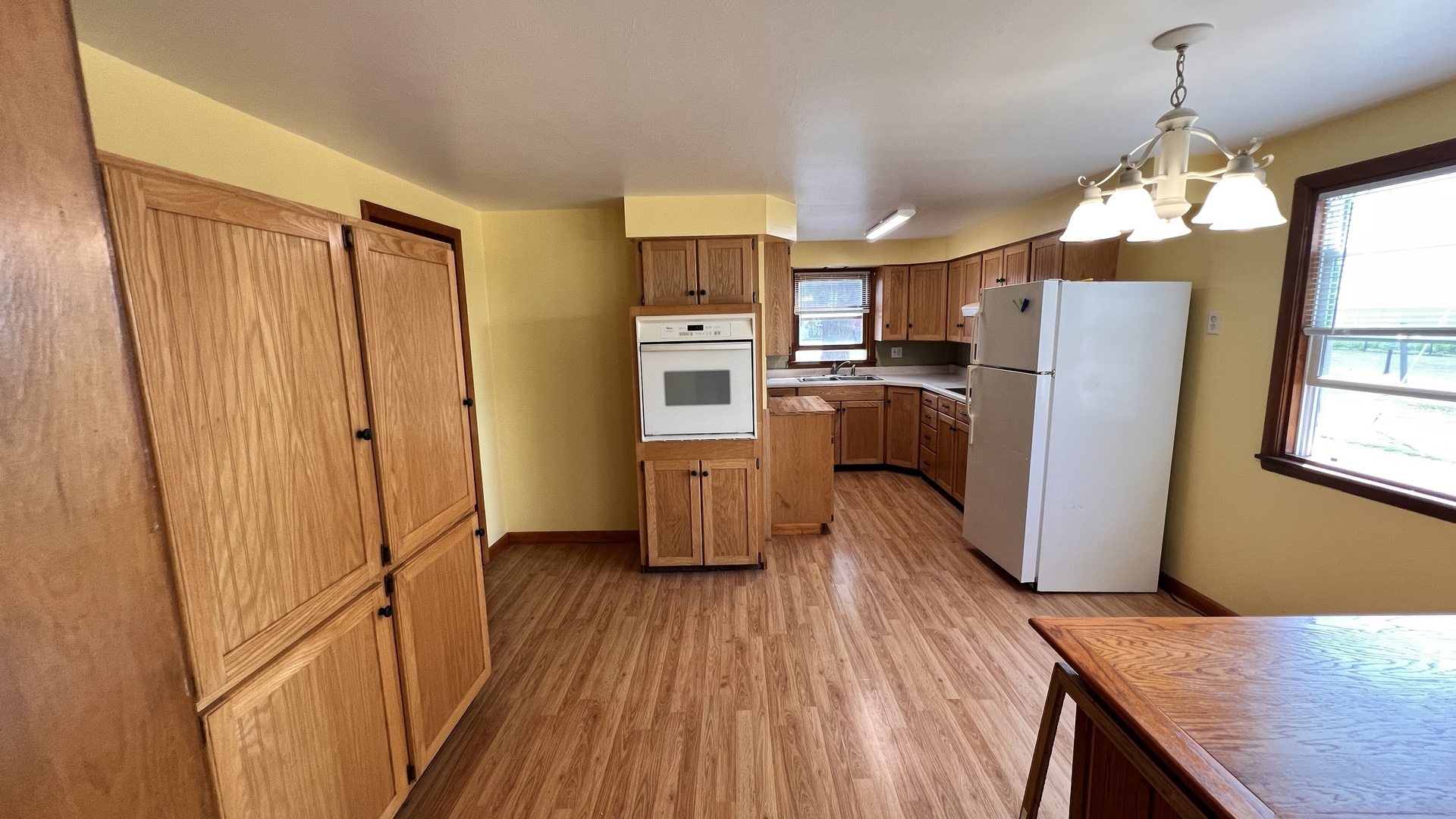 23160 Carroll Road Morrison, IL 61270 - Photo 30 of 44 a kitchen with kitchen island wooden floor window and refrigerator