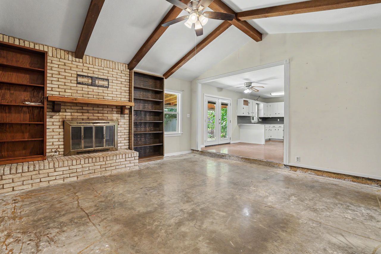 1811 Terry Lane Georgetown, TX 78628 - Photo 6 of 40 Exposed beam ceilings crown a spacious living area with an inviting brick fireplace and built-in shelving.