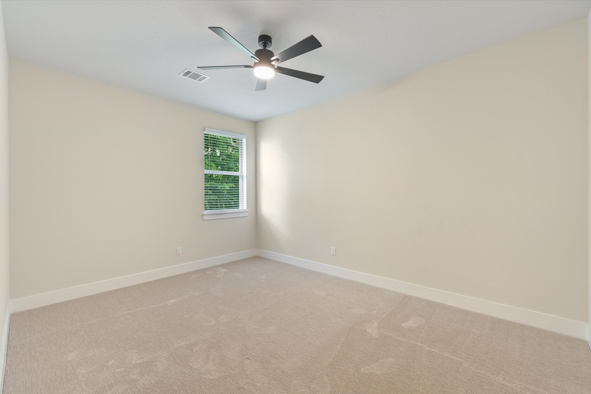 913 Presa Arriba Road Austin, TX 78733 - Photo 22 of 30 A well-lit bedroom with fresh carpeting and a modern ceiling fan, offering a comfortable personal retreat.