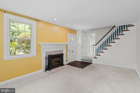 a view of an empty room with fireplace and a window