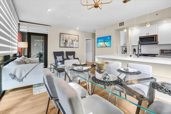 a living room with furniture kitchen view and a wooden floor