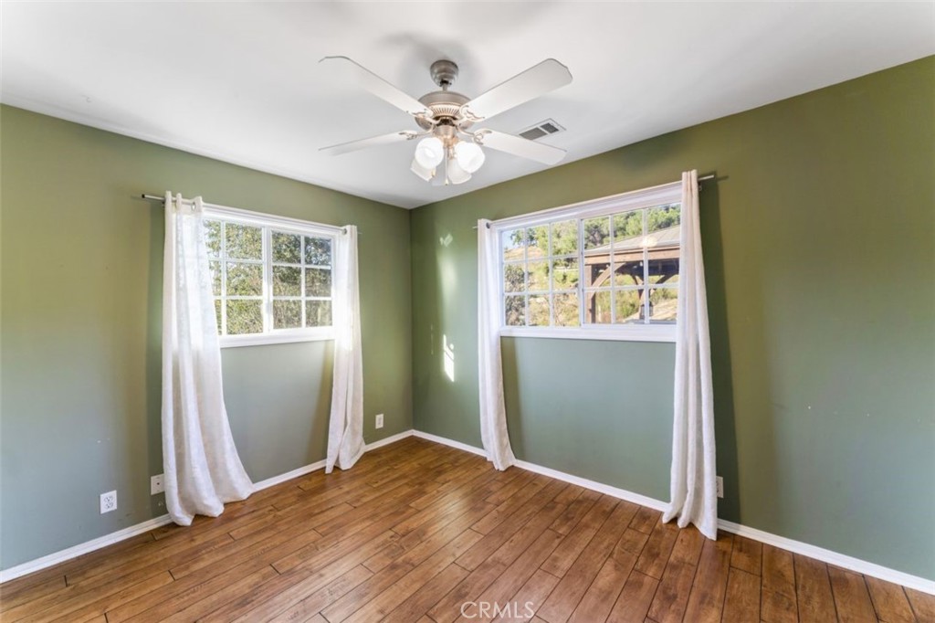7223 Tranquil Place Tujunga, CA 91042 - Photo 24 of 40 an empty room with wooden floor chandelier fan and windows