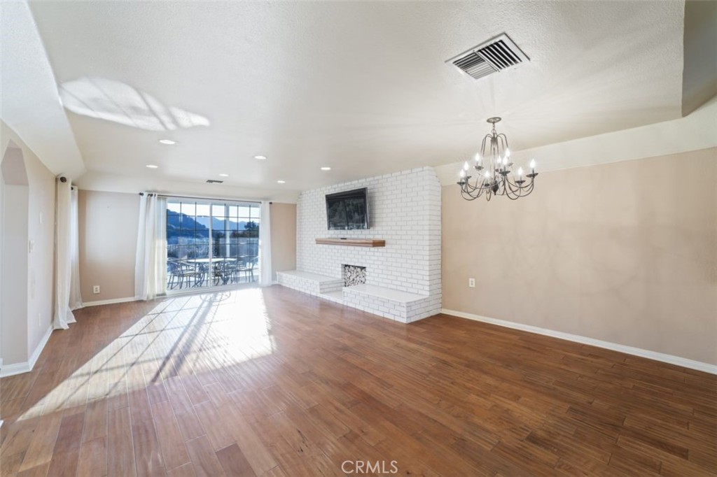 7223 Tranquil Place Tujunga, CA 91042 - Photo 30 of 40 a big room with wooden floor a chandelier a flat screen tv and a wooden floor