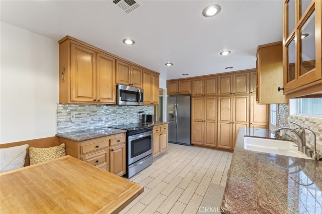 7223 Tranquil Place Tujunga, CA 91042 - Photo 10 of 40 a kitchen with stainless steel appliances granite countertop a stove top oven a sink dishwasher a refrigerator and cabinets with wooden floor