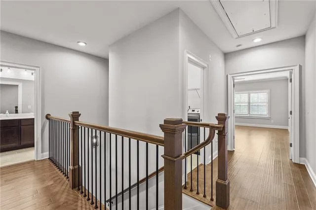 a view of a hallway with wooden floor and windows