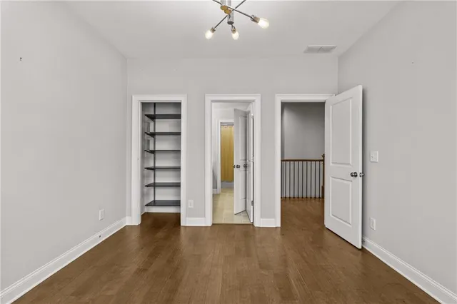 an empty room with a hallway and wooden floor