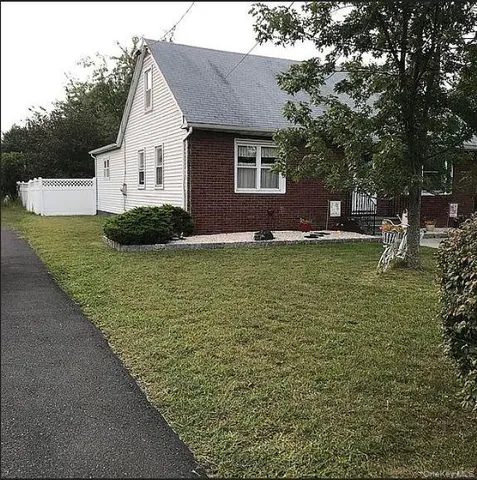 a view of an house with backyard space and tree