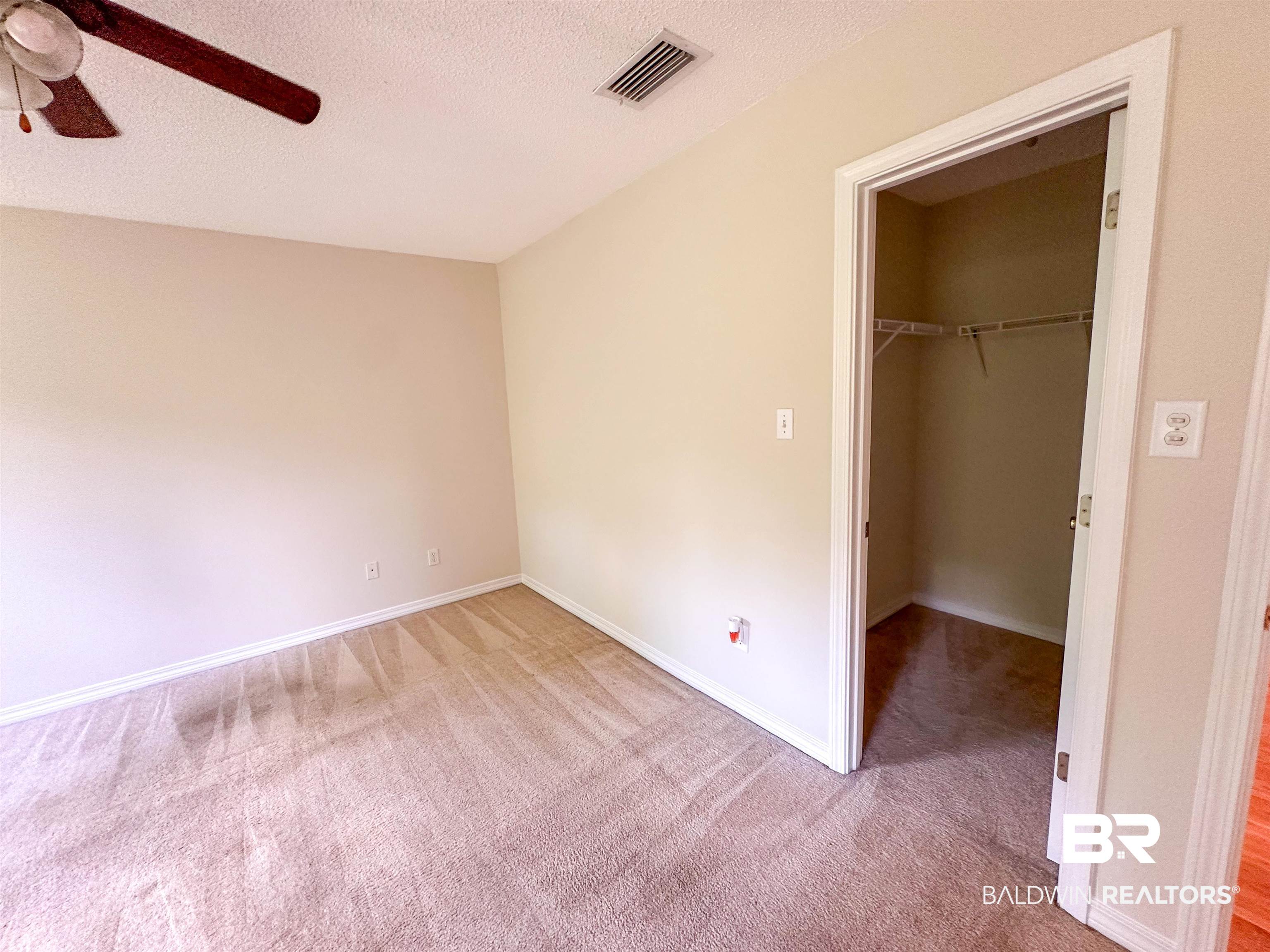 13255 Pointer Drive West Foley, AL 36535 - Photo 19 of 25 Unfurnished bedroom with a textured ceiling, a spacious closet, ceiling fan, carpet, and a closet