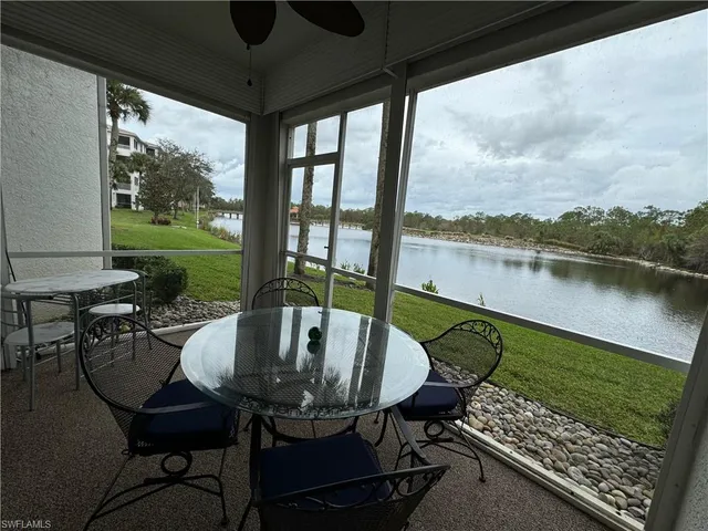 a view of a chairs and table in patio next to a yard