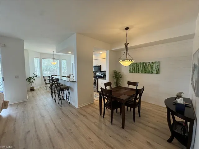 a dining room with furniture window entryway and wooden floor