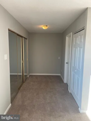 an empty room with closet and mirror