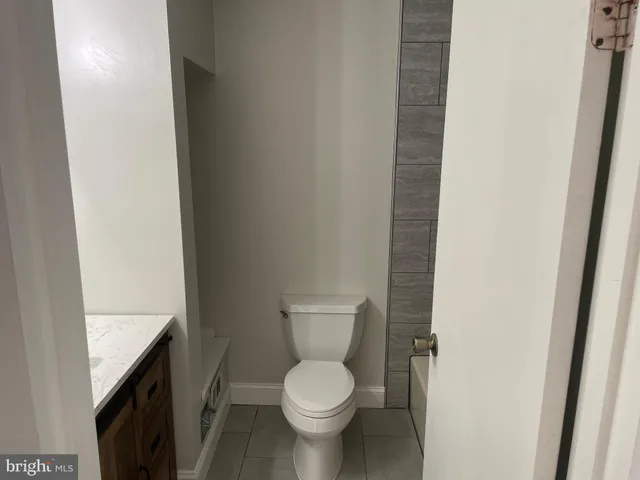 a white toilet sitting next to a shower