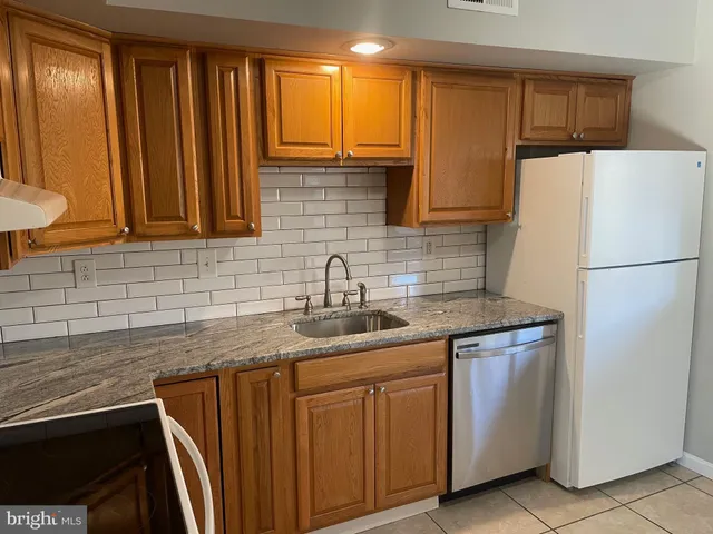 a kitchen with a sink a refrigerator and cabinets