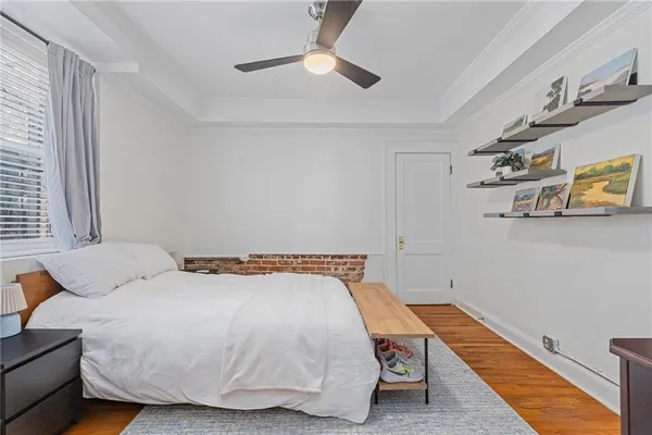 a bedroom with a bed and wooden floor