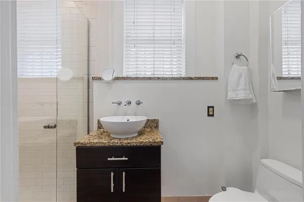 a bathroom with a granite countertop sink toilet and shower
