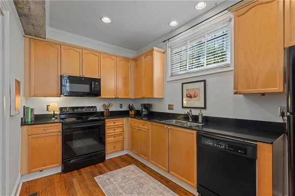 a kitchen with stainless steel appliances granite countertop a stove a sink and a microwave