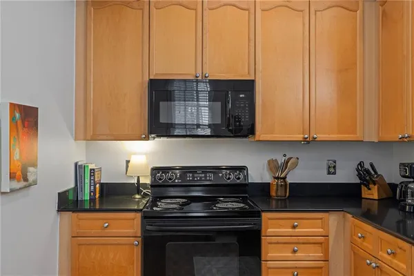 a kitchen with stainless steel appliances granite countertop a stove a sink and white cabinets