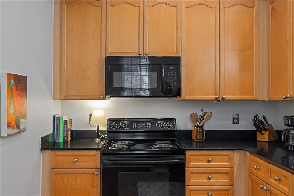 155 3rd Street Northeast, Unit 12 Atlanta, GA 30308 - Photo 9 of 36 a kitchen with stainless steel appliances granite countertop a stove a sink and white cabinets