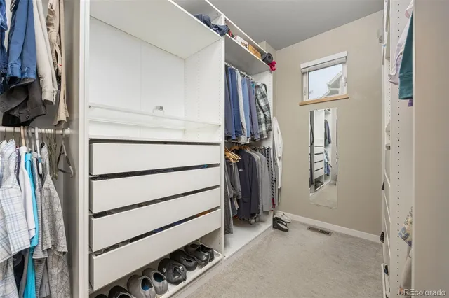 a view of walk in closet with clothes and shoes