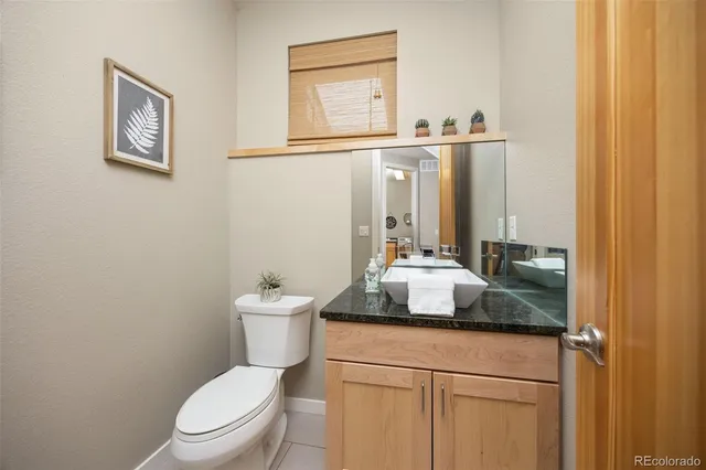 a bathroom with a granite countertop toilet sink and mirror