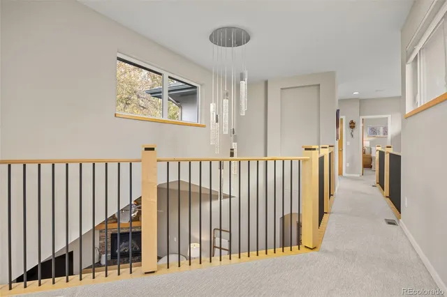 a view of a hallway with wooden floor and windows