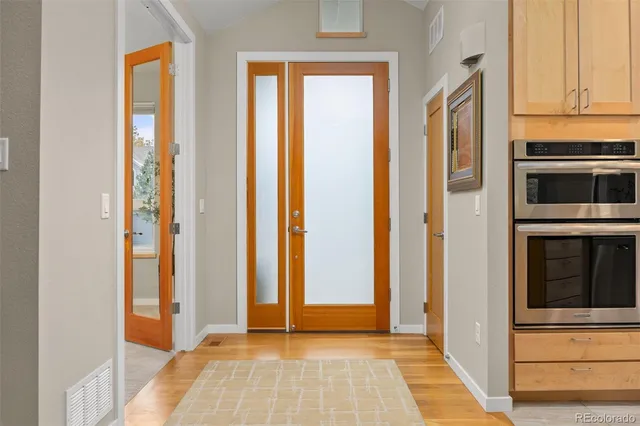 a view of a hallway with wooden floor and staircase
