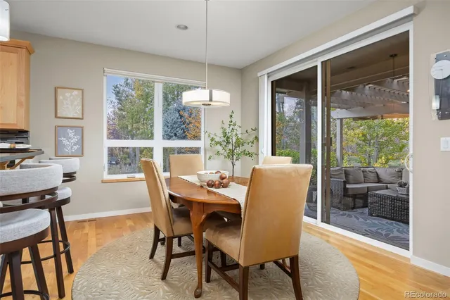 a dining room with furniture large windows and wooden floor