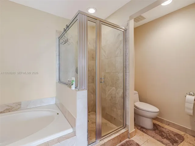 a bedroom with a bed a chandelier and a window