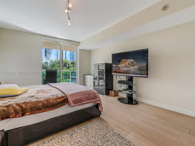 a spacious bedroom with a bed table chair and a window