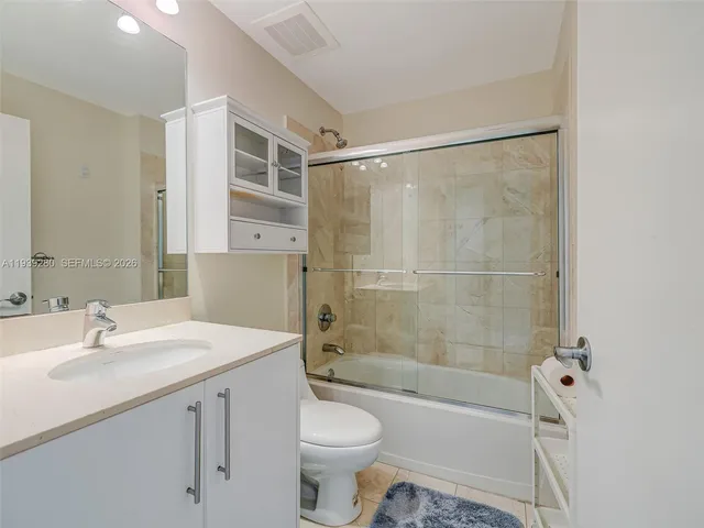 a view of a white house with a big yard and potted plants