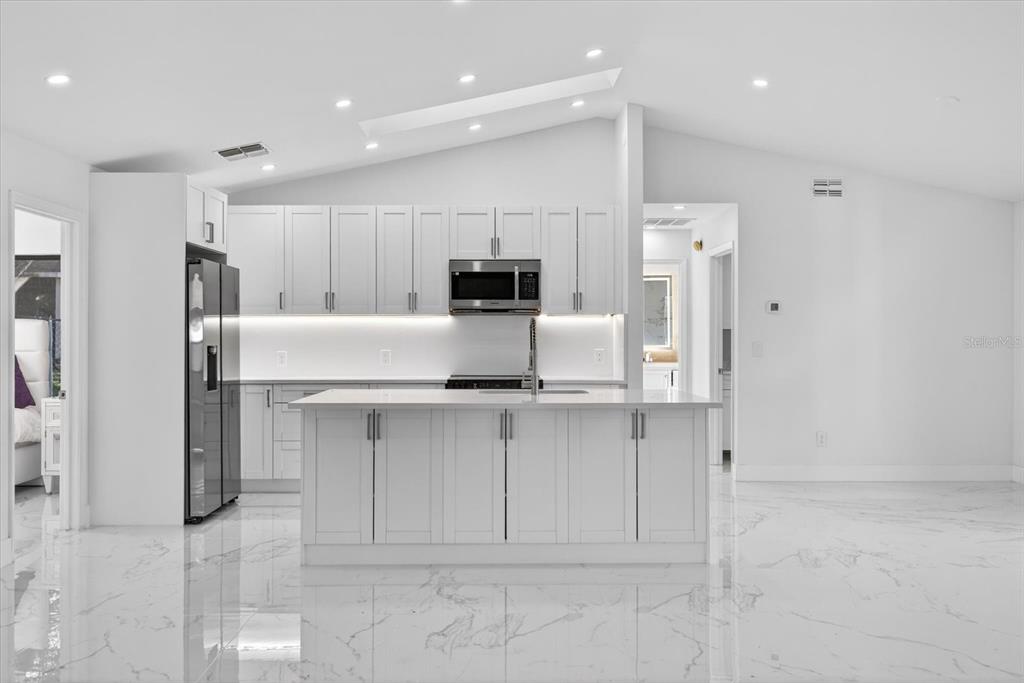 8078 Pagoda Drive Spring Hill, FL 34606 - Photo 9 of 54 a kitchen with kitchen island cabinets and refrigerator