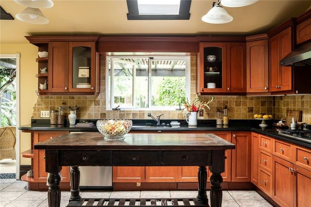 a kitchen with granite countertop a sink stove and cabinets