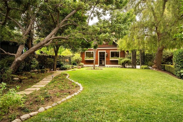a view of house with a backyard