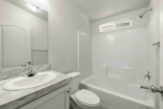 a bathroom with a shower sink vanity and mirror