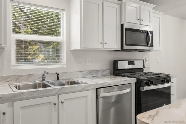 a kitchen with a stove a sink and a refrigerator
