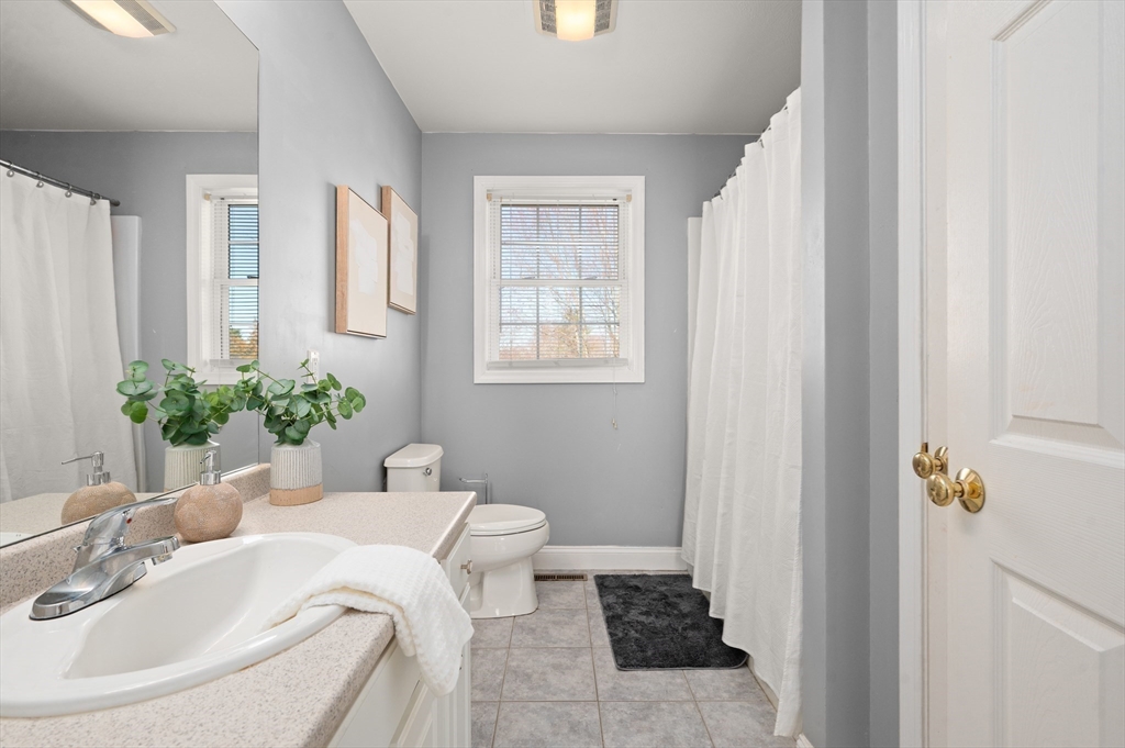 104 Overlook Terrace Dracut, MA 01826 - Photo 27 of 39 a bath room with a toilet and a mirror