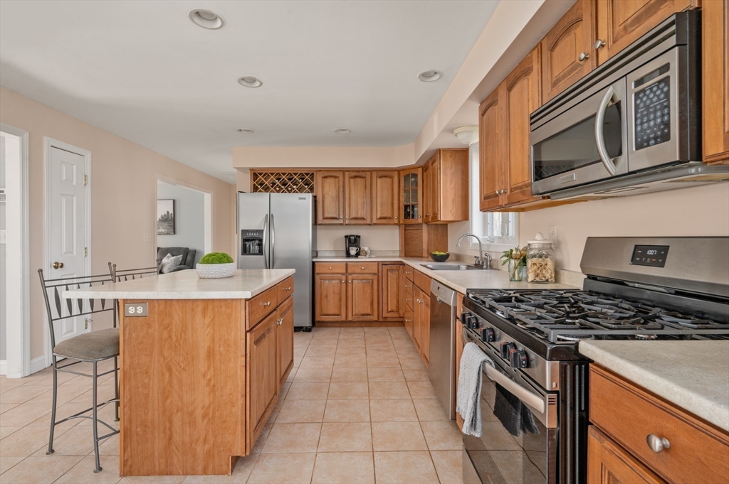 104 Overlook Terrace Dracut, MA 01826 - Photo 10 of 39 a kitchen with stainless steel appliances granite countertop a stove top oven a sink dishwasher and cabinets with wooden floor
