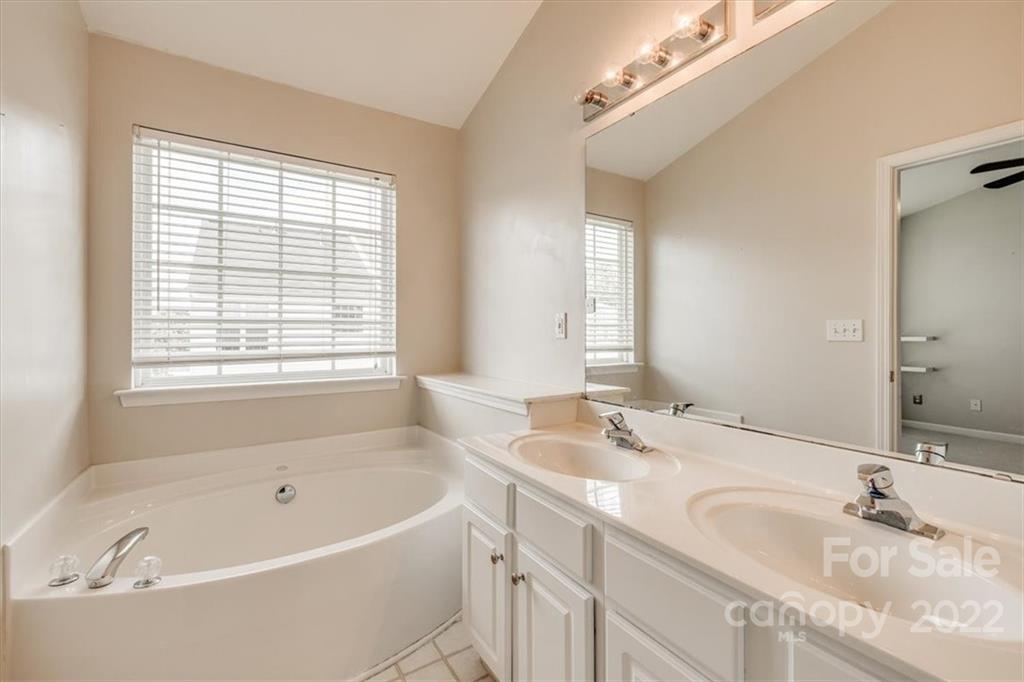 2126 Midnight Blue Lane Fort Mill, SC 29708 - Photo 33 of 35 a bathroom with a granite countertop tub sink and mirror