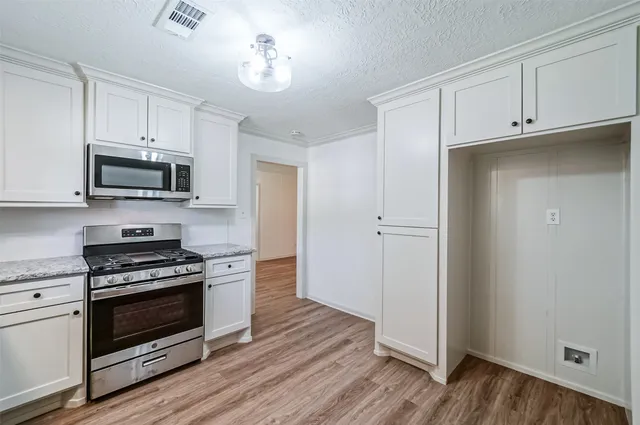 a kitchen with granite countertop wooden floors and stainless steel appliances