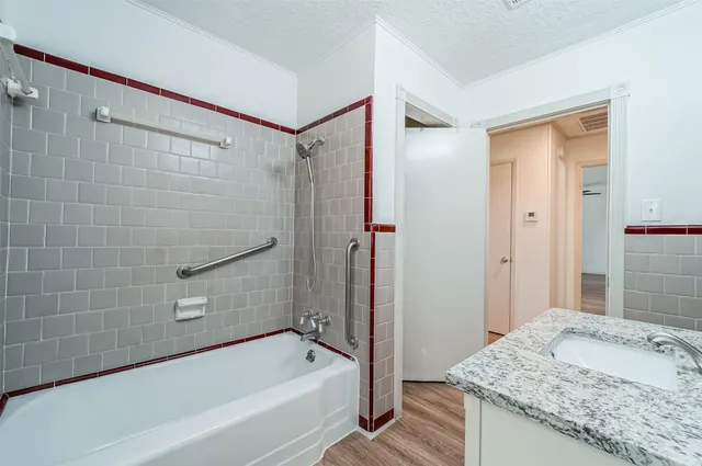 a bathroom with a granite countertop sink a mirror and a bathtub
