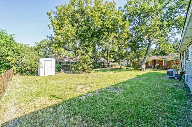 a view of a yard with a house and a large tree