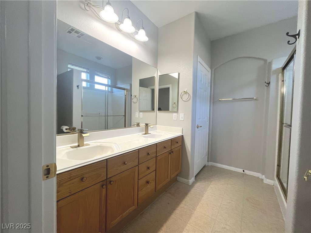 231 Spectacular Street Henderson, NV 89052 - Photo 36 of 66 Primary bath with double sinks, oak cabinets, cultured marble countertop, walk in shower & linen closet