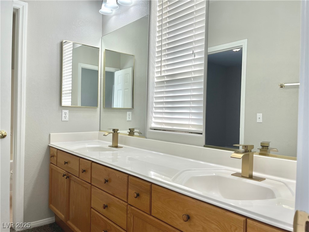 231 Spectacular Street Henderson, NV 89052 - Photo 44 of 66 Jack and Jill bath with double sink, cultured marble countertop, oak cabinets and shower/tub combo