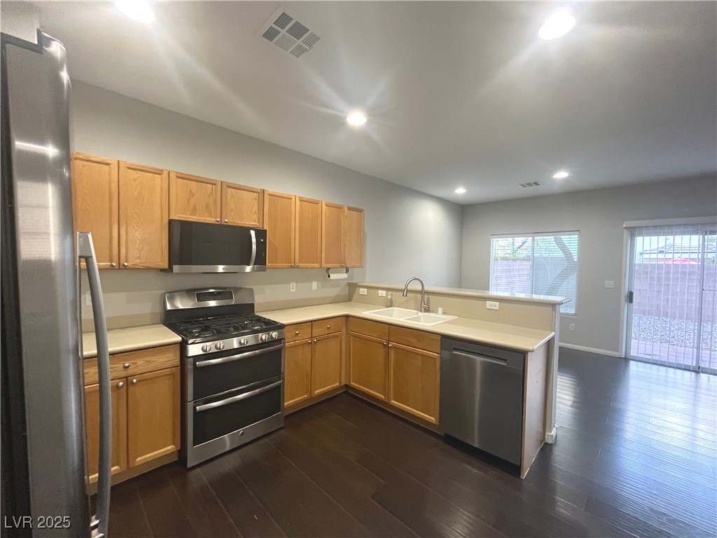 231 Spectacular Street Henderson, NV 89052 - Photo 5 of 66 Kitchen with breakfast nook/bar, oak cabinets, wood laminate flooring, corian countertops, recesses lighting, SS appliances and pantry