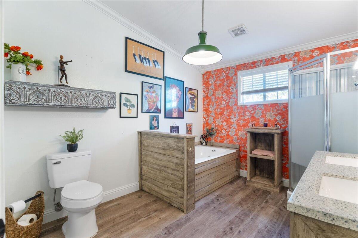 3562 Bob Tolbert Road Navarre, FL 32566 - Photo 19 of 55 a spacious bathroom with a granite countertop toilet a sink and a large mirror