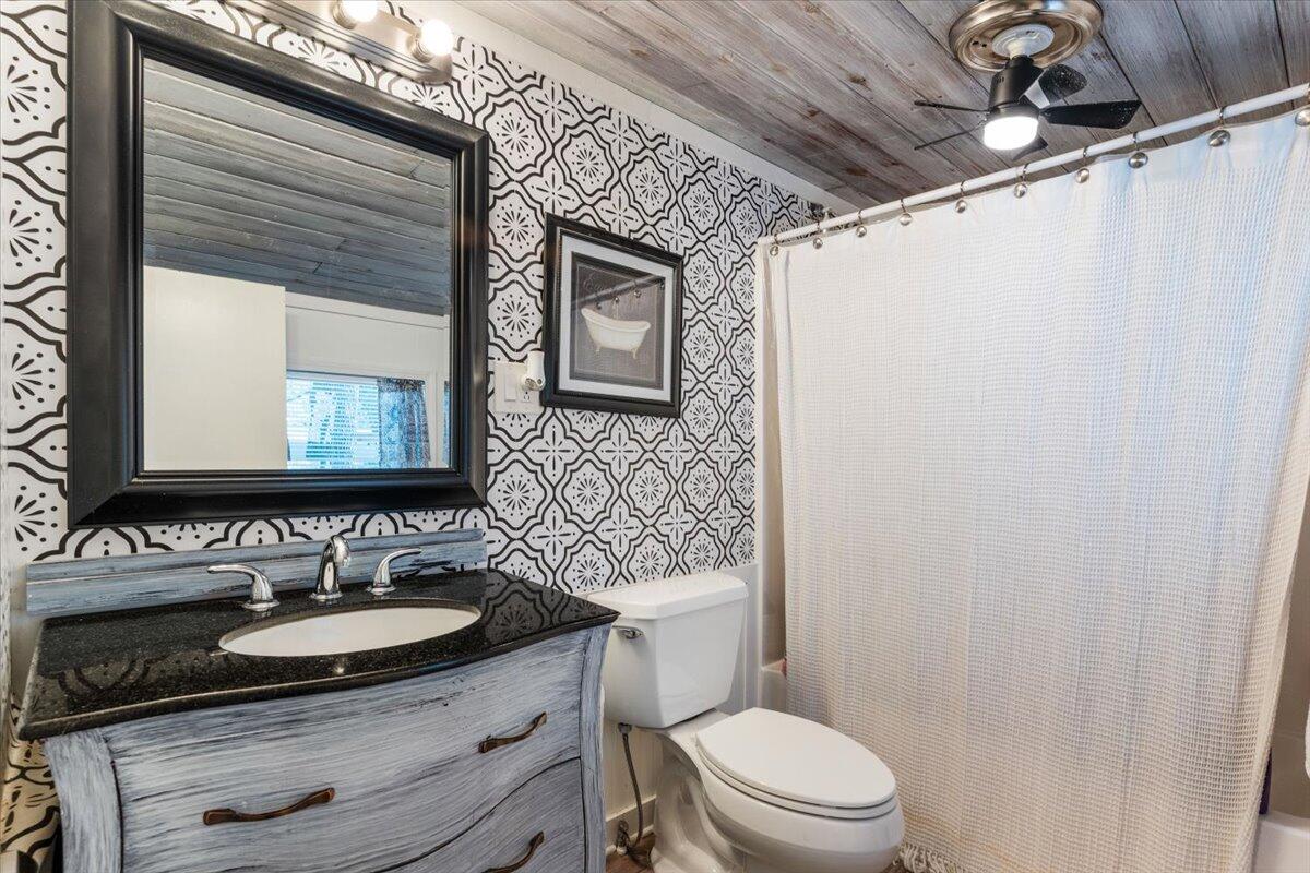 3562 Bob Tolbert Road Navarre, FL 32566 - Photo 25 of 55 a bathroom with a sink toilet a mirror and vanity