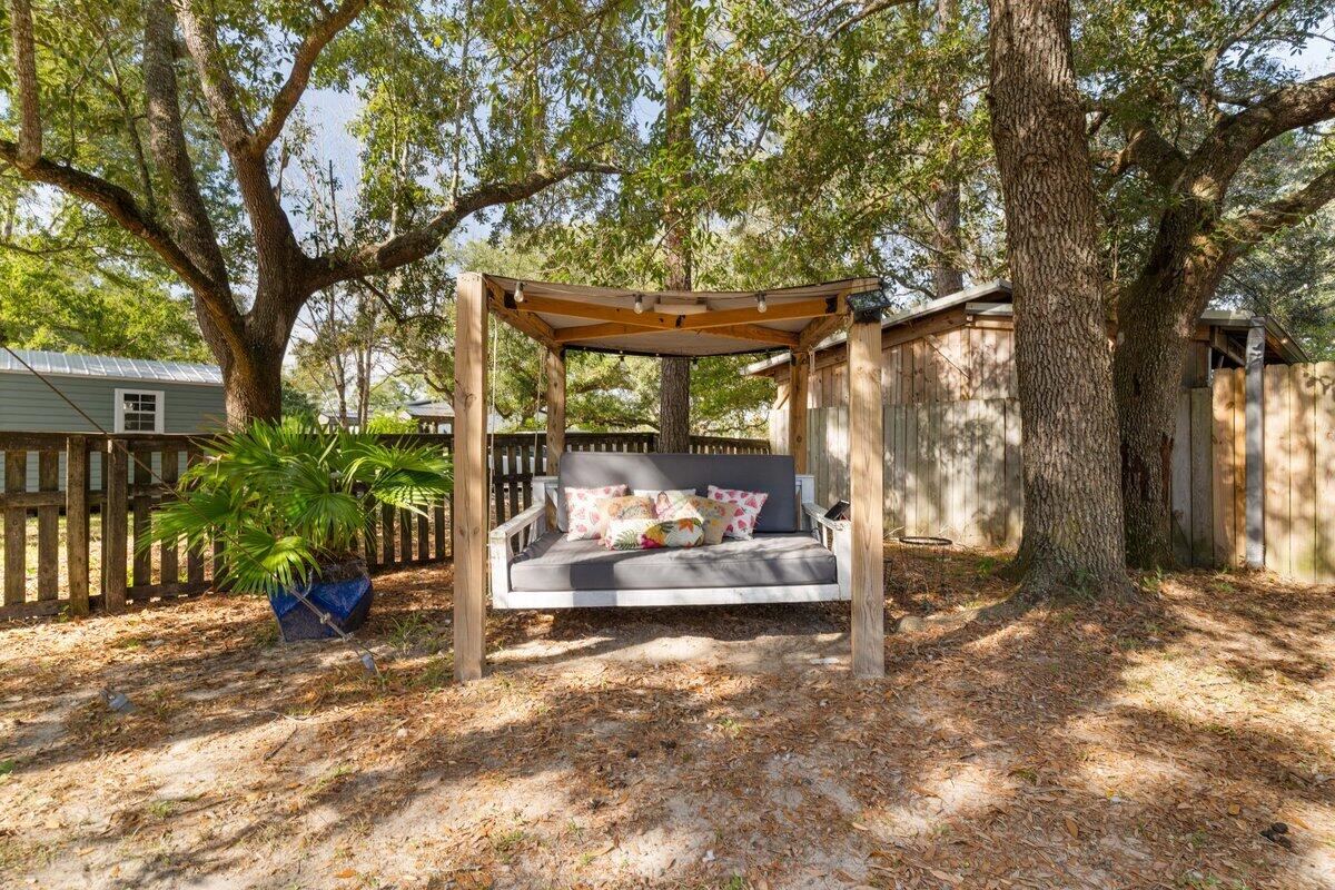 3562 Bob Tolbert Road Navarre, FL 32566 - Photo 3 of 55 a view of a patio with table and chairs next to a large tree