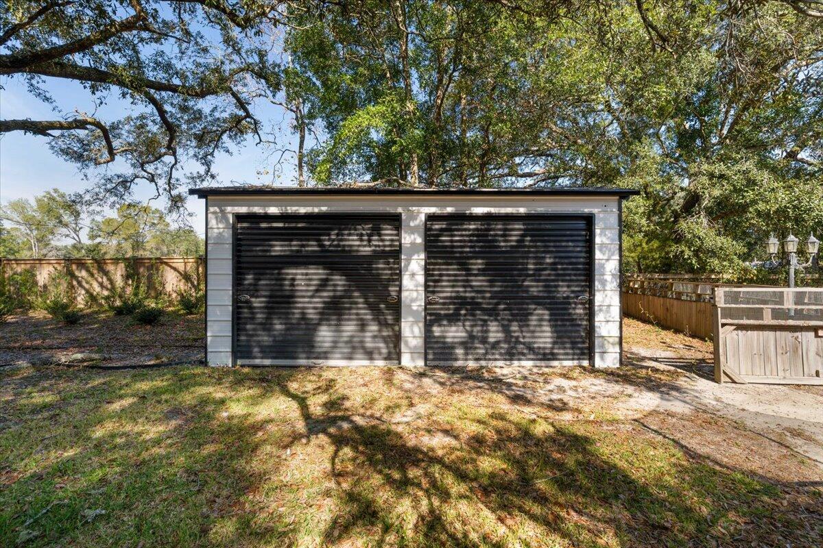 3562 Bob Tolbert Road Navarre, FL 32566 - Photo 34 of 55 a view of backyard with large tree and wooden fence