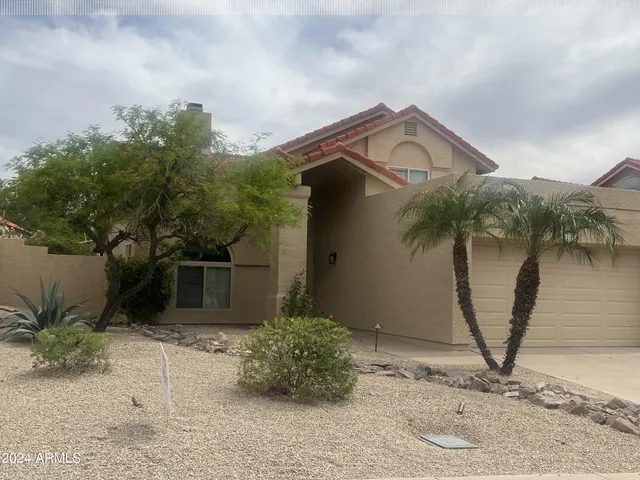 a view of a house with a wooden fence