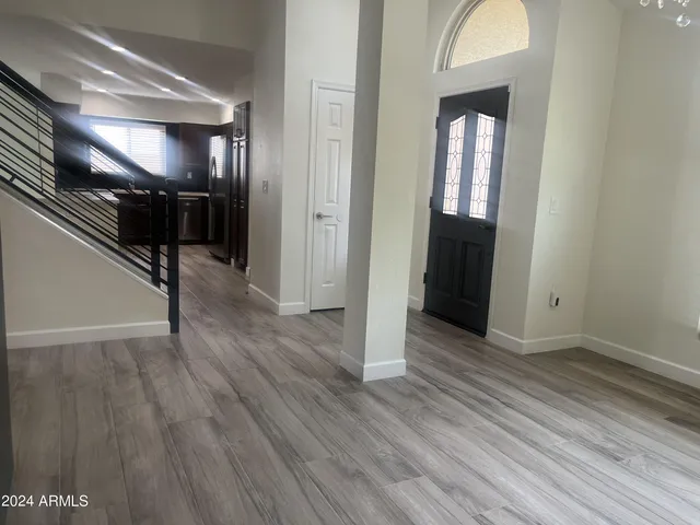 a view of an empty room with wooden floor fire place and a fireplace